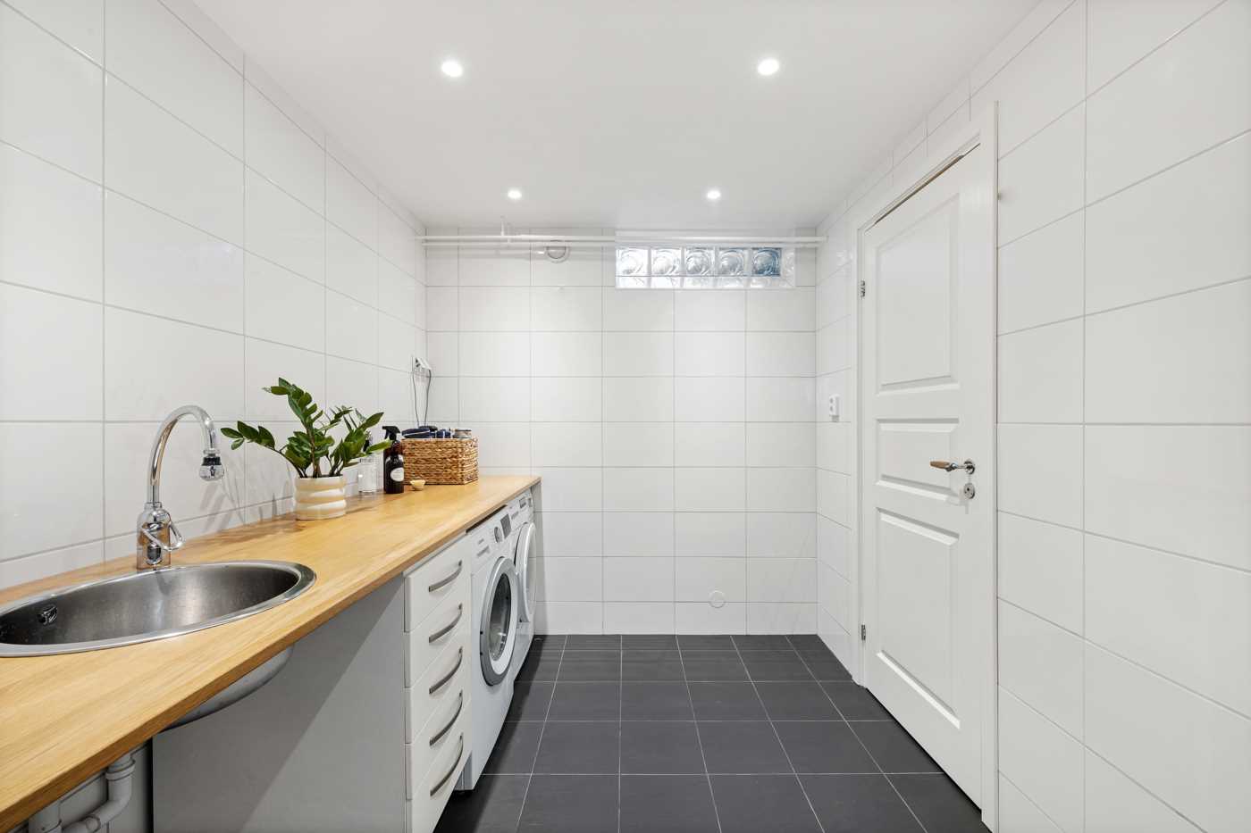 Rymlig och fräsch tvättstuga med ingång till förråd