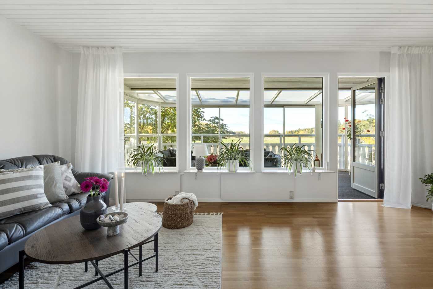 Stort vardagsrum med fint fönsterparti med utgång till uterummet