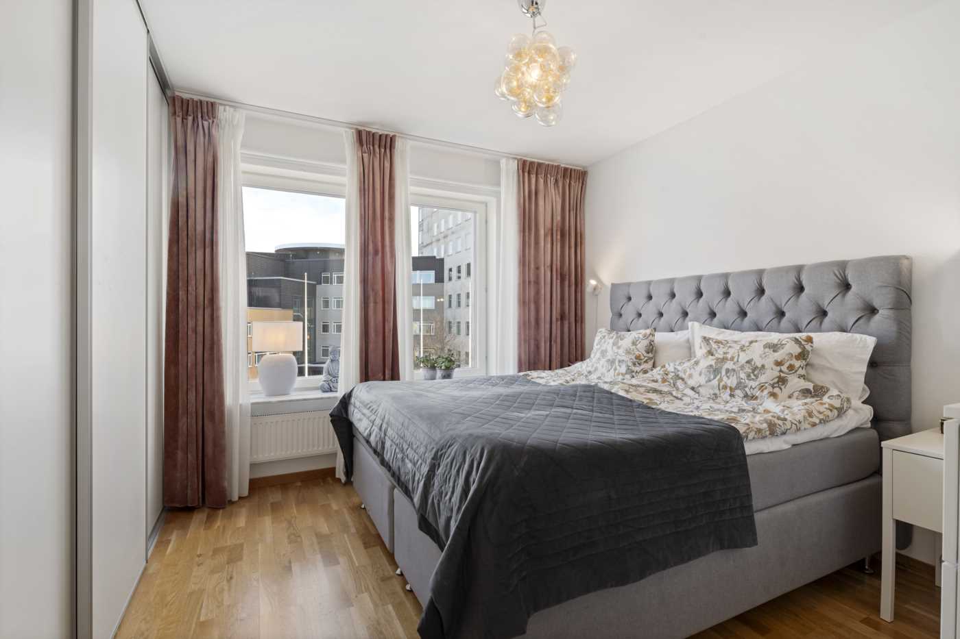 Ett av två sovrum med plats för dubbelsäng och fin förvaring i skjutdörrsgarderob