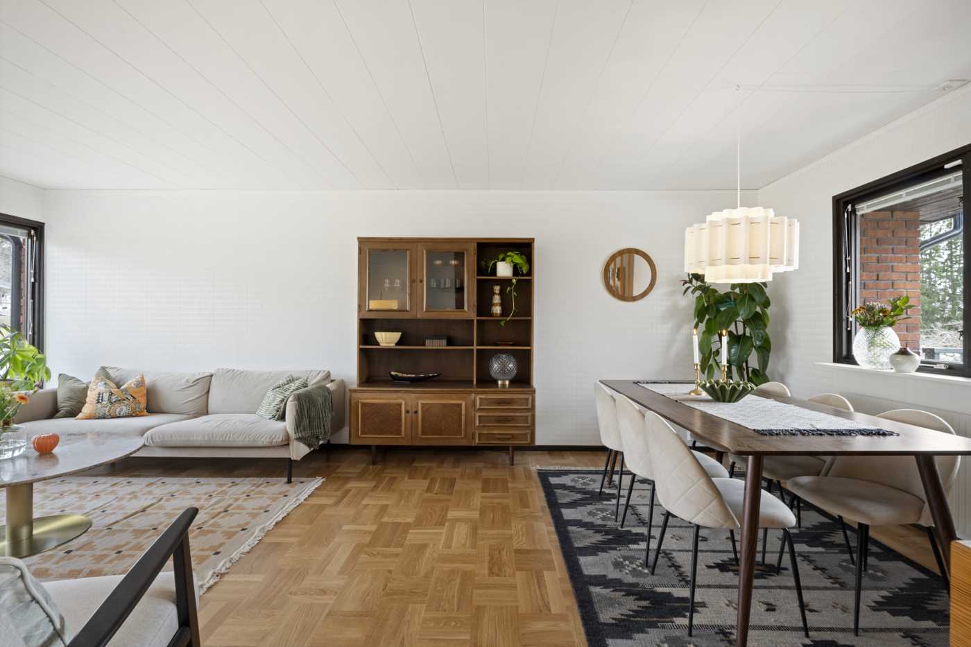 Stort vardagsrum med middagsgrupp