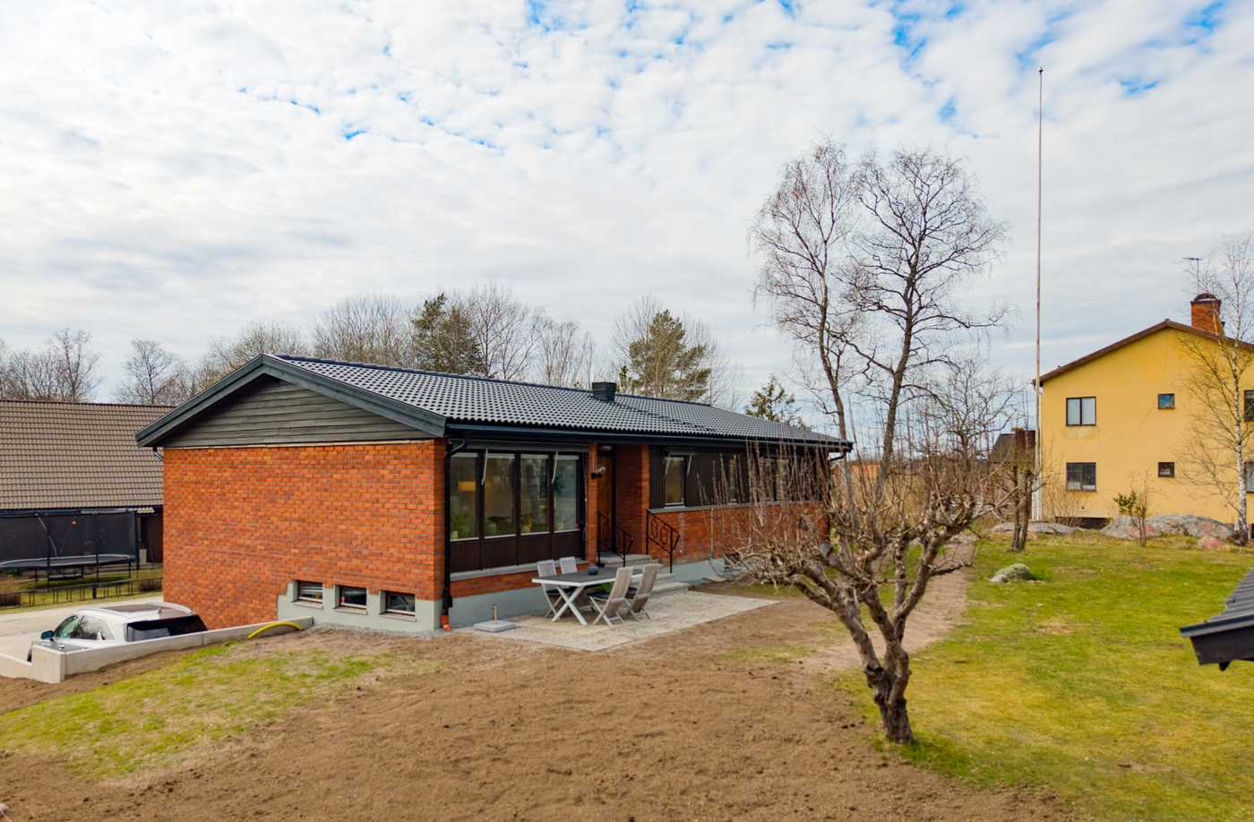 Trivsam trädgårdssida med uteplats