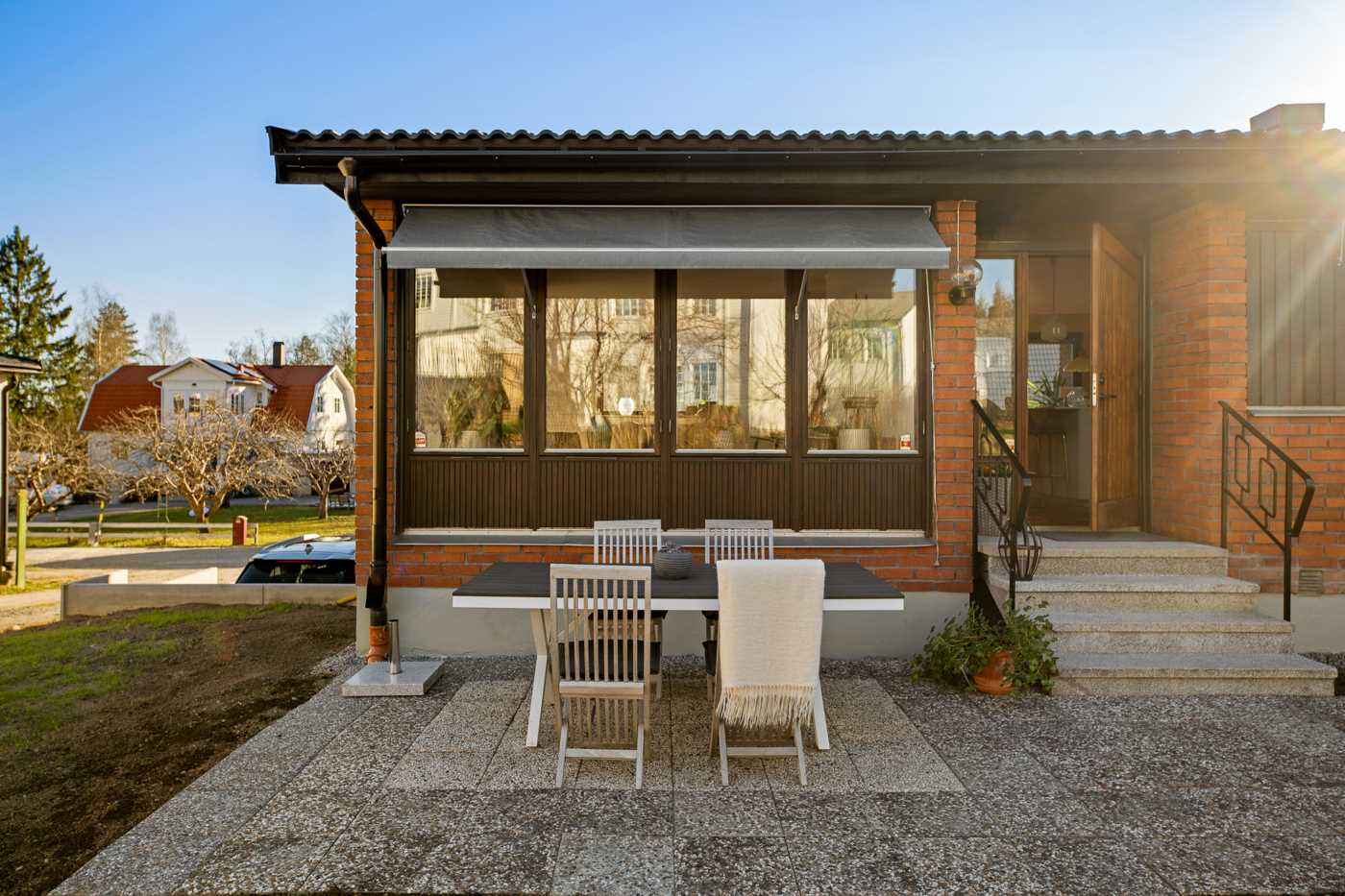 Stenlagda uteplatsen med dörr in till kök & vardagsrum