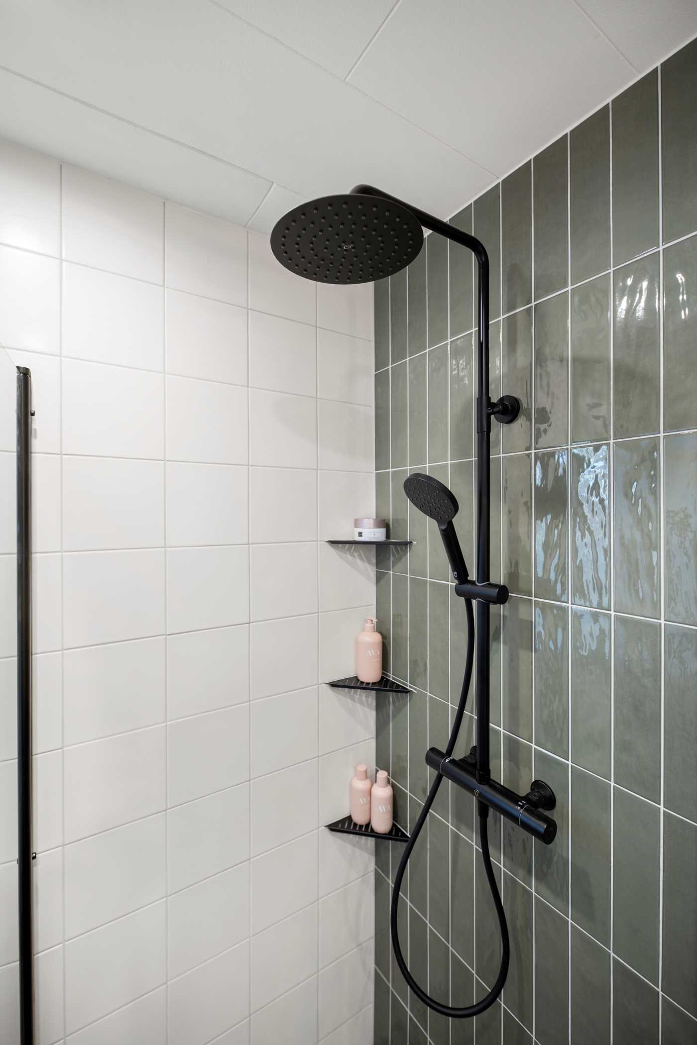 Vacker grön nyans på kakel och stilfull takdusch i svart